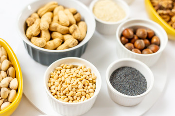 Various Nuts and Seeds on White Background in the Bowls - Image