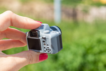 Woman hand holding small toy camera. Taking photos, photography, creative, artist concept.