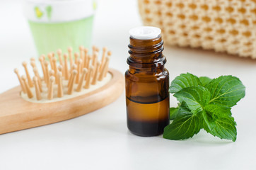 Small bottle with essential peppermint oil. Fresh mint leaves close up. Aromatherapy, spa and herbal medicine ingredients. Copy space    © kazmulka