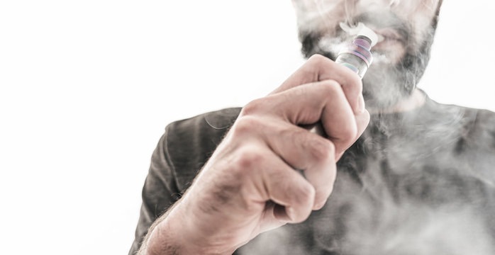 adult caucasian man with beard vaping e-cigarette as tobacco alternative against white background