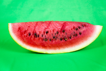 Fototapeta na wymiar Close-up of a piece of refreshing watermelon on a light green background. Raw organic fruit. Useful product