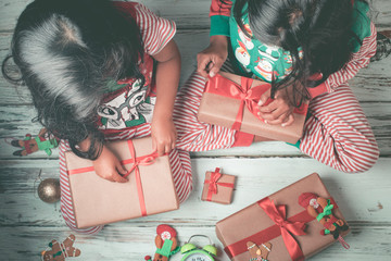 Little sisters opening their gifts on Christmas day