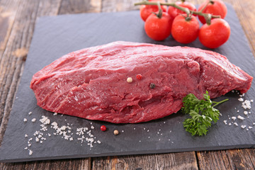 raw beef piece with herb and salt on board