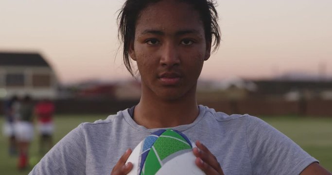 Portrait of young mixed race adult woman rugby player on a rugby pitch