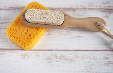 Yellow spongewashcloth with pumice. Self-care items on a wooden background, zero waste concept. Copy space