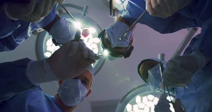 Upward view of Multi-ethnic Surgeons performing surgery in operation theater at hospital