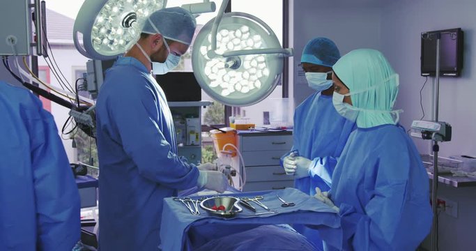 Side view of Caucasian surgeon performing operation in operation theater