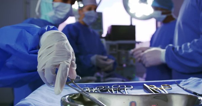 Multi-ethnic surgeons performing surgery in operation room at hospital