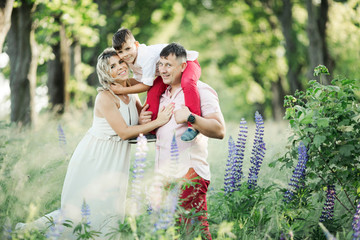 a family stands and hugs among a greenery park