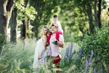 a family stands and smiles among flowers and trees