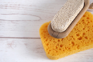 Yellow spongewashcloth with pumice. Self-care items on a wooden background, zero waste concept. Copy space