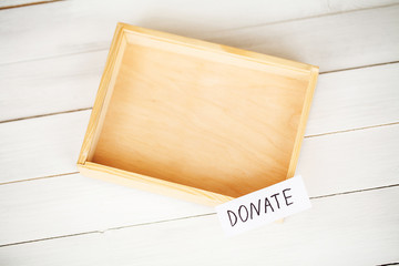 Donate conception. Box with money on white wood background