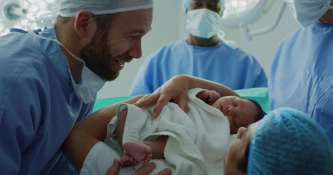 Close-up of Caucasian couple looking at their newborn baby in hospital