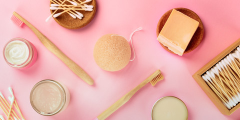 Fototapeta na wymiar A panorama of plastic-free, zero waste cosmetics, flat lay pattern on a pink background. Bamboo toothbrushes and cotton swabs, konjac sponge, natural organic products