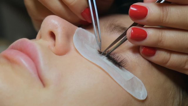 Eyelash Extension Procedure. Woman Eye with Long Eyelashes. Lashes, close up