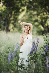 a young pregnant woman poses among greenery lawn