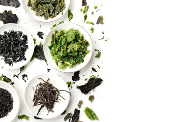 Fototapeta na wymiar Dry seaweed, sea vegetables, shot from the top on a white background with copy space, a design template with a flat lay composition and a place for text