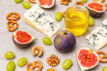 Cheese appetizer selection or wine snack set. Blue cheese, figs, honey, walnuts, pretzels