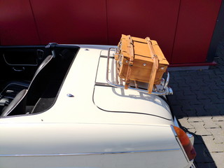 Weißer offener Roadster und Sportwagen Klassiker der Sechzigerjahre mit Gepäckbrücke und Koffer...