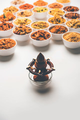 Rangoli of Farsan/snacks in bowls for Diwali with diya