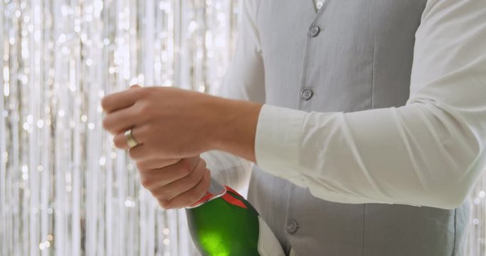 Young man opening champagne