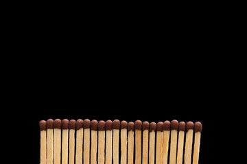 A row of matches on a black background. Horizontal photo.