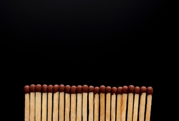 A row of matches on a black background.
