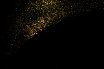 Fototapeta na wymiar Golden glitter scattered on black bacground, selective focus