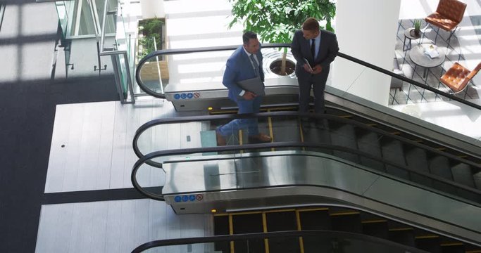 Businessmen on an escalator in a modern building