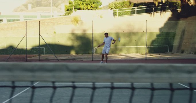 Man playing tennis on a sunny day