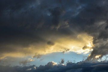 Sunbeam over storm clouds at sunset