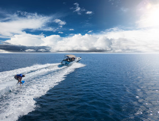Speedboat with wakeboard rider on open sea
