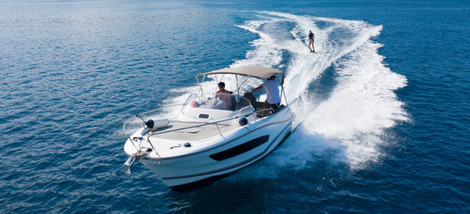 Speedboat with wakeboard rider on open sea - Powered by Adobe