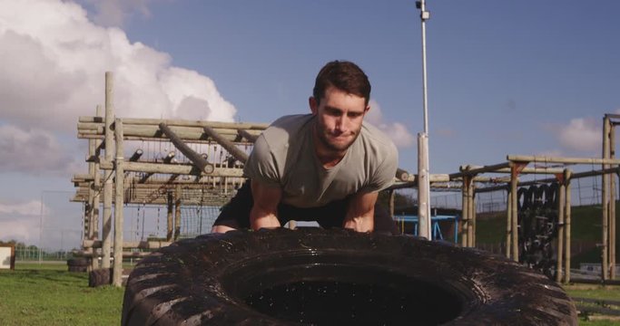 Young man training at an outdoor gym bootcamp