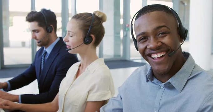 Young business people using headsets in a modern office