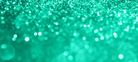Abstract composition. Blurred photo of glitter with beautiful bokeh in trendy mint. Defocused light.