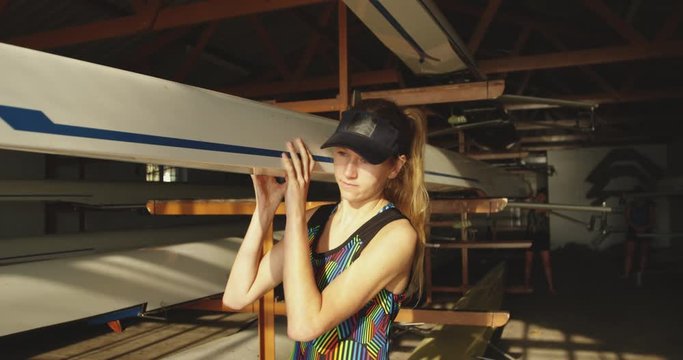 Female rower carrying a scull