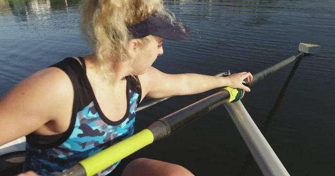 Female rower in a boat on a river