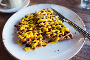 Tasty veggie dessert -  waffles with lemon cream. close up dish with fork and knife.