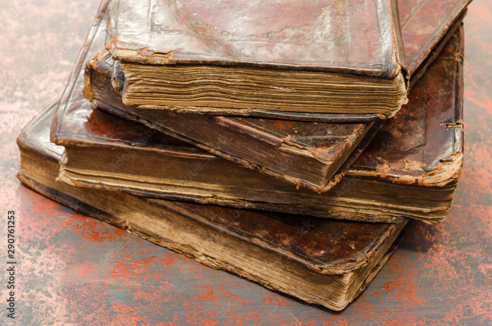 Wall mural stack of old and worn leather cover books with gold leaf embossing. closeup - Wall murals