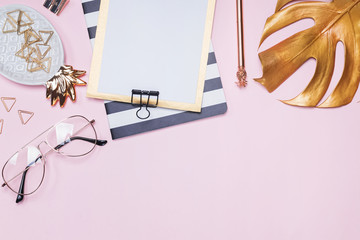 Golden color decor and stationery on pink background,
