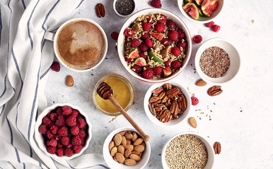 Ingredients for a healthy breakfast, oatmeal with raspberries, figs, pecans, almonds, flax seeds, chia seeds with honey and coffee. Good morning, health concept. Top view