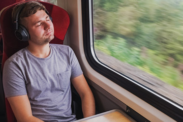 Young man in headphones sitting with his eyes closed