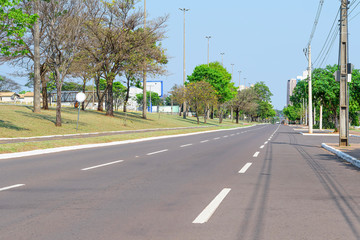 Large one way avenue with trees around. Afonso Pena avenue at Campo Grande - MS, Brazil.