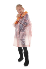 Full shot of a little blonde girl dressed in a pink nacre raincoat, black jeans, black top and black high shammy boots. The raincoat with pockets is buttoned with press-studs, 