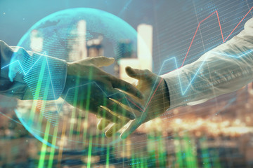 Double exposure of financial chart and world map on cityscape background with two businessmen handshake. Concept of international investment