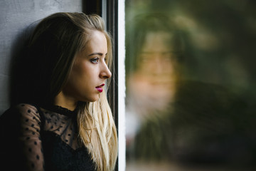 a girl portrait sideway near a window
