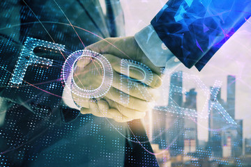 Double exposure of financial graph on cityscape background with two businessman handshake. Concept of stock market deal