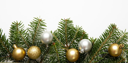 Fir twig and christmas baubles, white background
