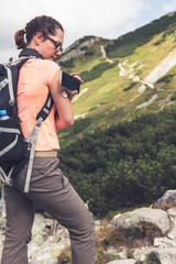 Active life of diabetics, woman hiking and checking glucose level with a remote sensor and mobile...